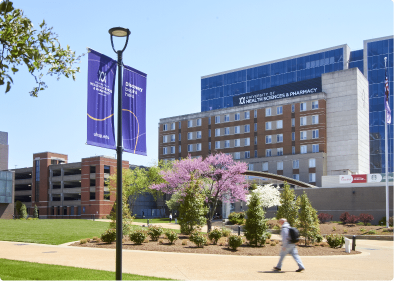 view of the center of UHSP campus with a student walking across the quad