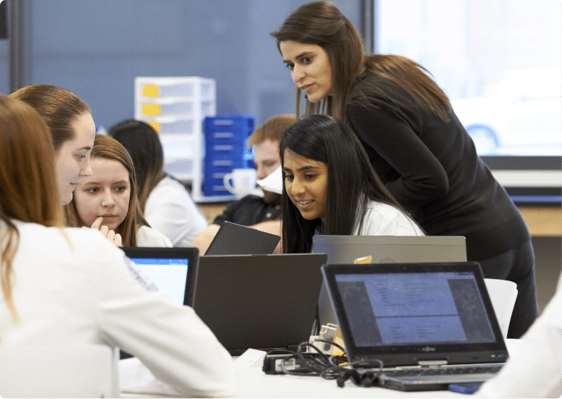 Pharmacy professor advises as students work in a group