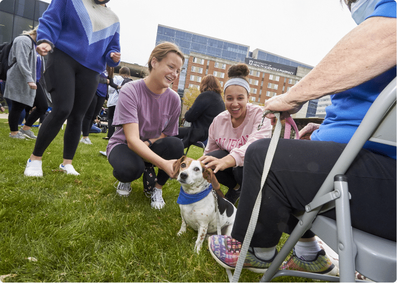 UHSP students interacting with pet therapy dogs on the quad.