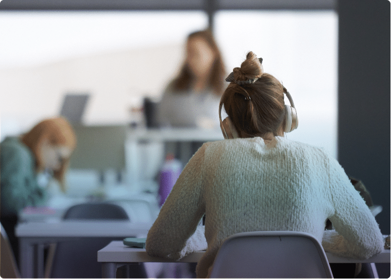 UHSP student in library with headphones on.