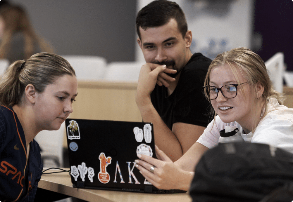 A group of UHSP students huddle around a laptop