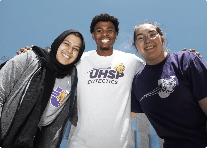 Three smiling students pose for the camera