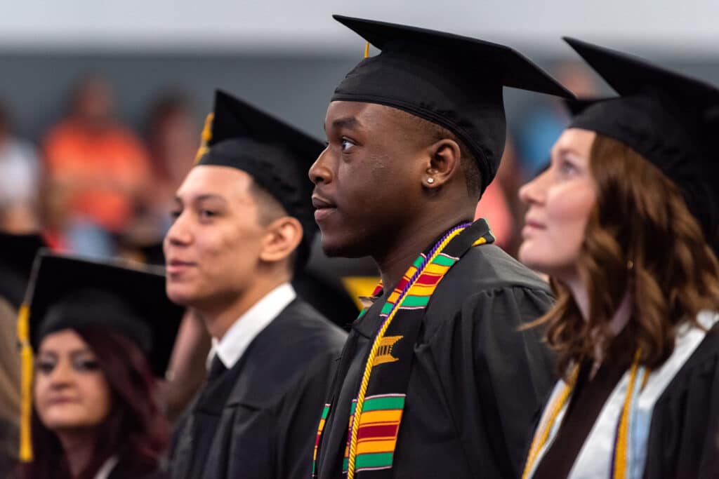 Students look on during undergraduate commencement ceremony. Apply Now.