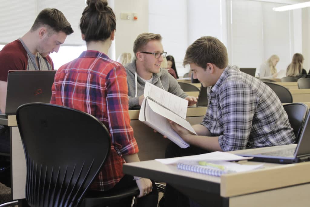 Students huddle together in a lecture hall