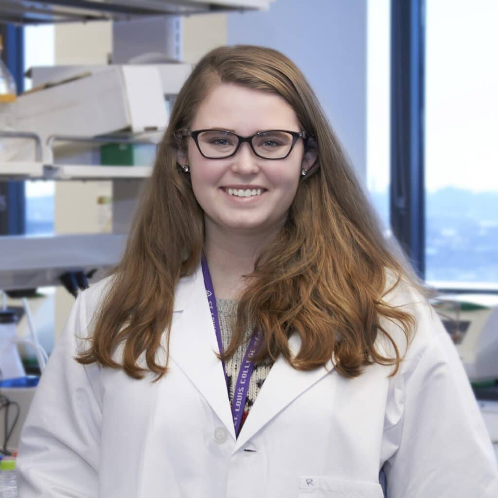 student Kaitlyn Danforth smiles at camera while working in the Clinical Pharmacology lab