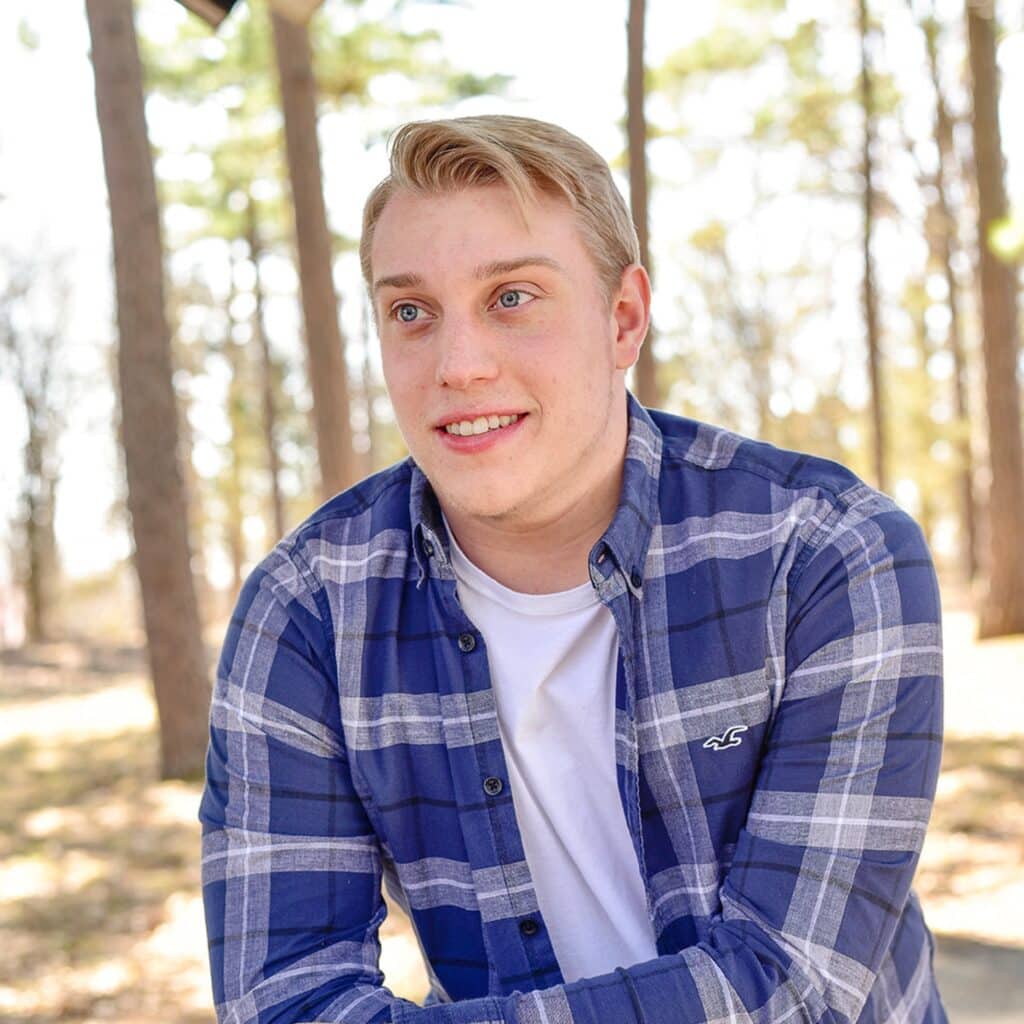 student colten duvall standing in the forest