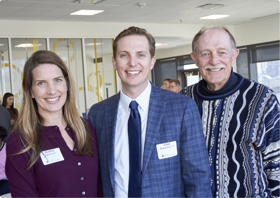 Two alumni smile to camera during a UHSP alumni event.