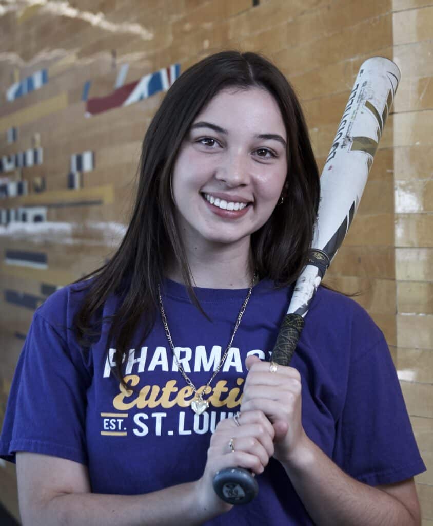 student Michelle Hollon poses with softball bat held to her shoulder