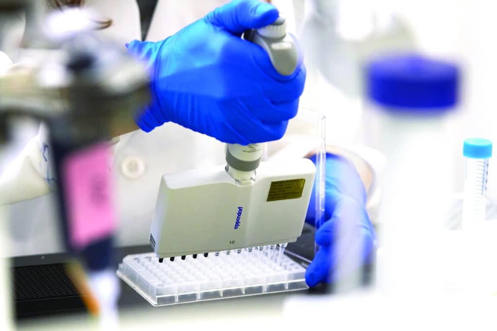 Lab worker empties pipettes into vials