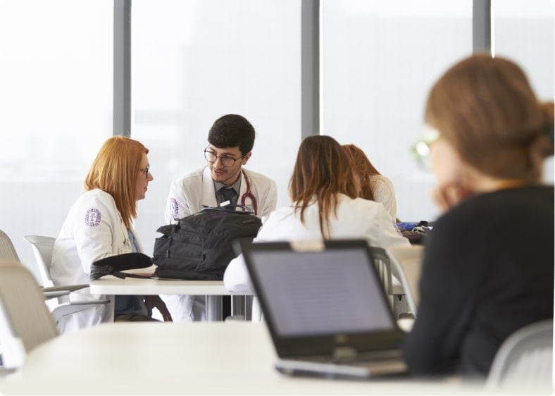 Pharmacy Students wearing lab coats sitting in lecture