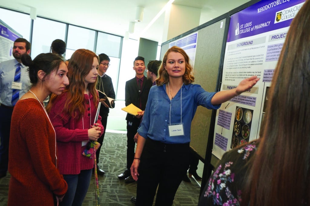 A student gives a presentation to her peers in a research symposium