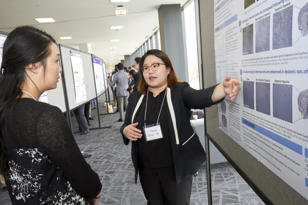 Student presents findings poster during student research symposum