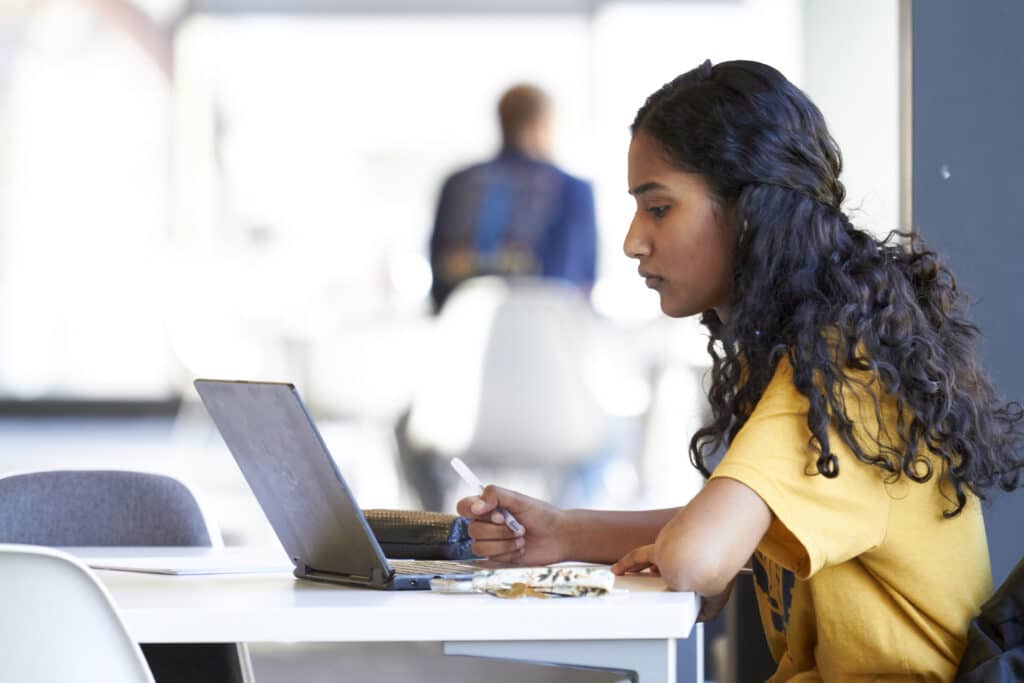 UHSP student working on a laptop in the library