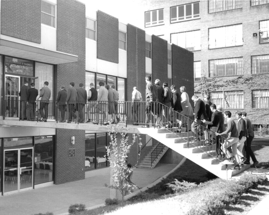 Students walking into a residence hall in 1964