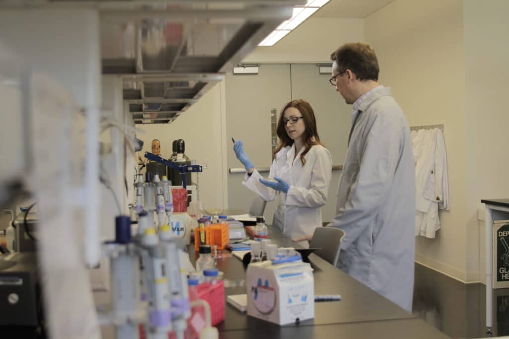 Student and researcher in laboratory.