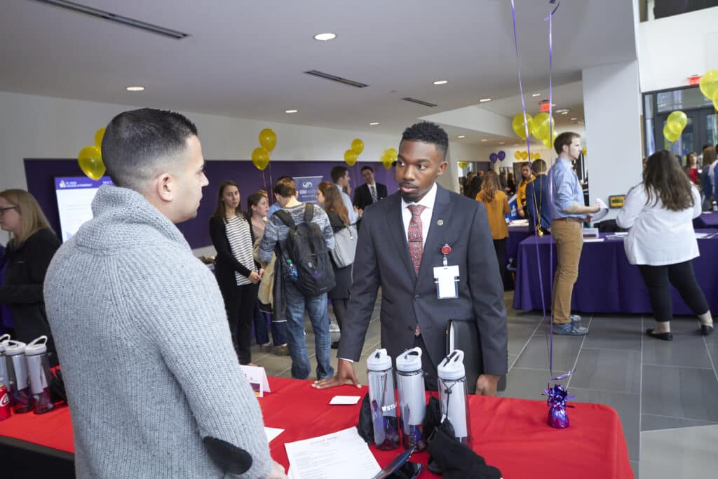 Student meets with potential employer during career fair and residency showcase.