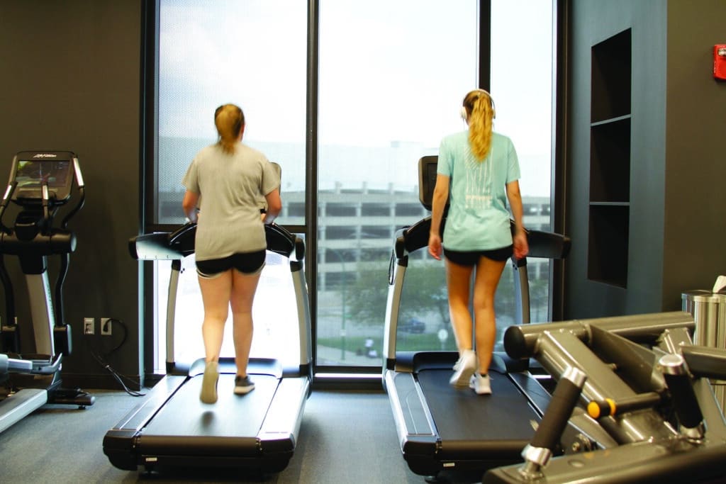 Female students walking on treadmills in the Fitness Center