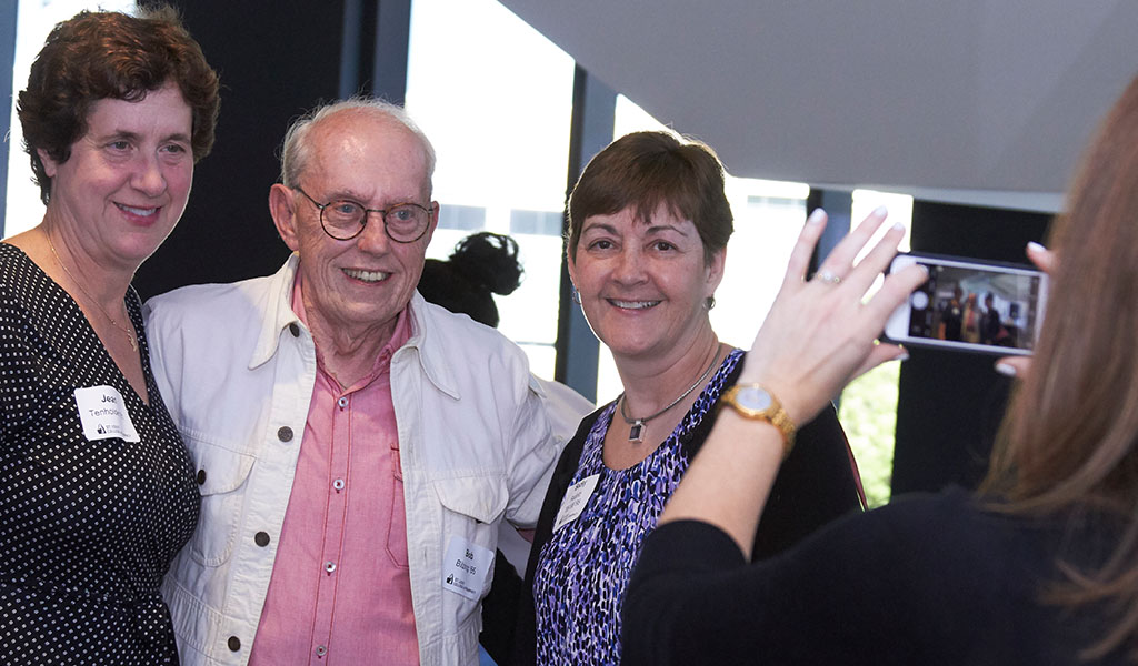 Alumni gets their picture taken at a reception event.