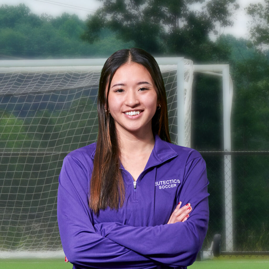 UHSP student-athlete Michelle Le smiles with arms crossed in front of soccer goal