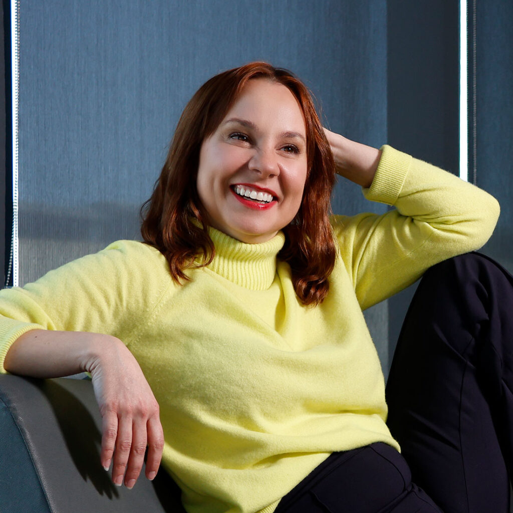 Student pharmacist Angela Robichaud smiles while casually lounging in chair