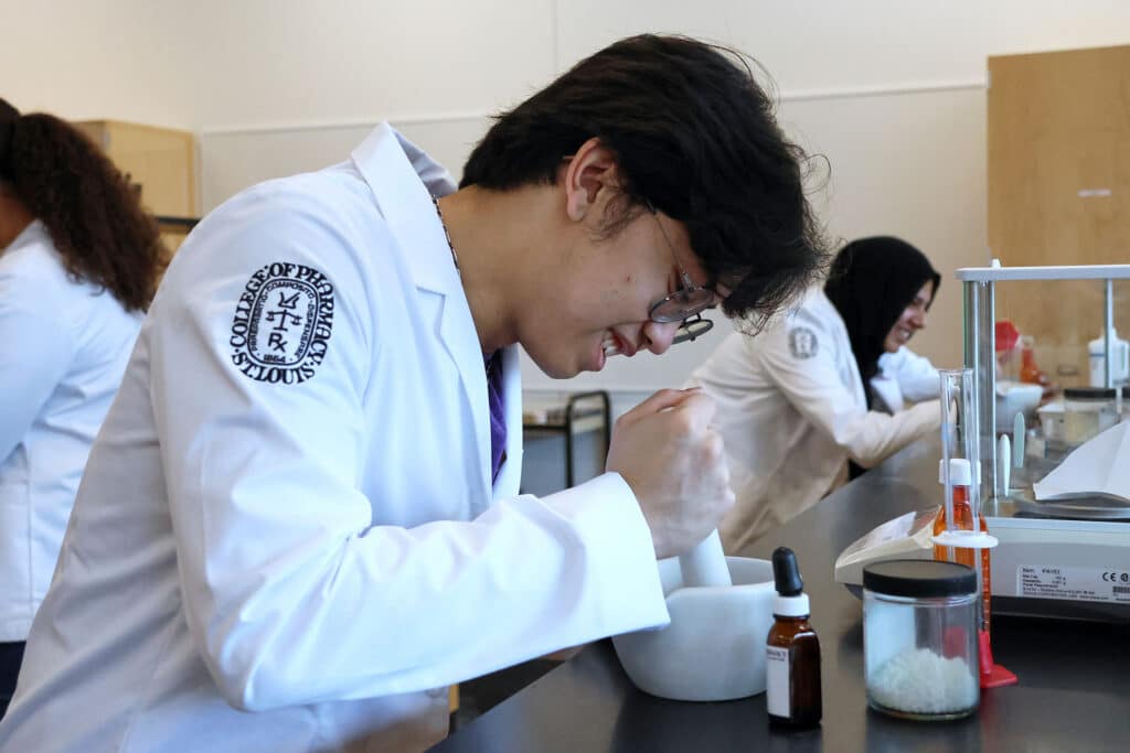 pharmacy student muddles ingredients in the lab